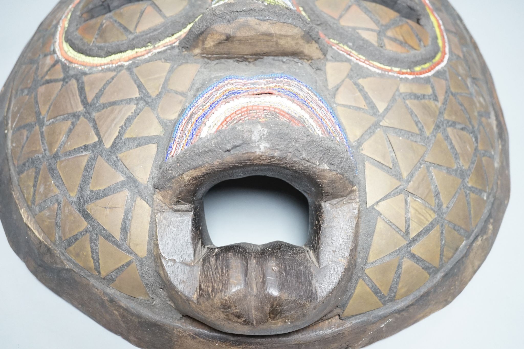 Two Japanese carved wood masks, an African beaded mask and three similar rattles